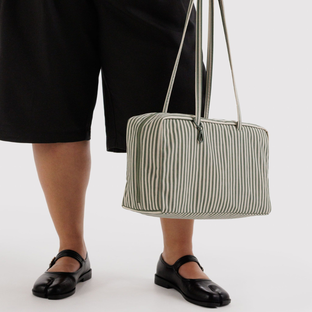 Baggu Person holding a striped bag against a white background