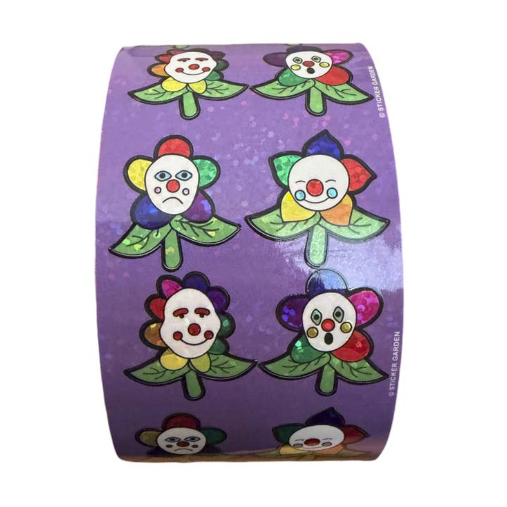 A roll of decorative washi tape featuring a purple background with cartoon clown flower designs in various colorful expressions.