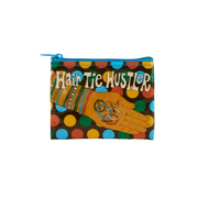 A zippered pouch featuring a colorful graphic print with the text 'Hair Tie Hustler' and an illustration of a hand wearing colorful hair ties and rings, set against a light gray background.