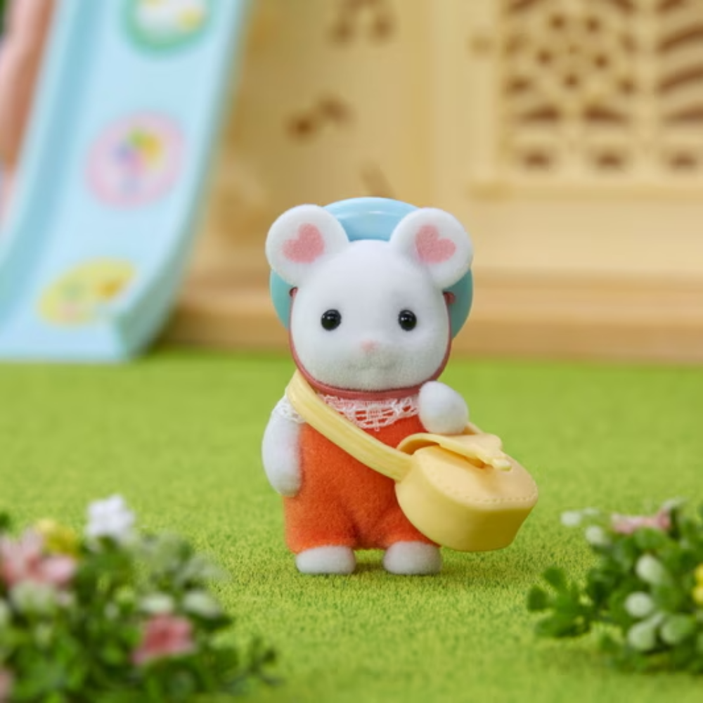 Toy mouse figure with a blue hat and orange overalls holding a yellow bag on a green surface.