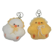 Two fluffy chick-shaped keychains on a plain white background. One is white with a yellow bonnet and orange beak/feet, and the other is pale yellow with a white bow and orange beak/feet.