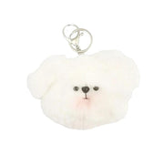 A fluffy white faux-fur keychain shaped like a small dog face, with black embroidered eyes and nose and a pink stitched blush, attached to silver metal key rings on a plain light background.