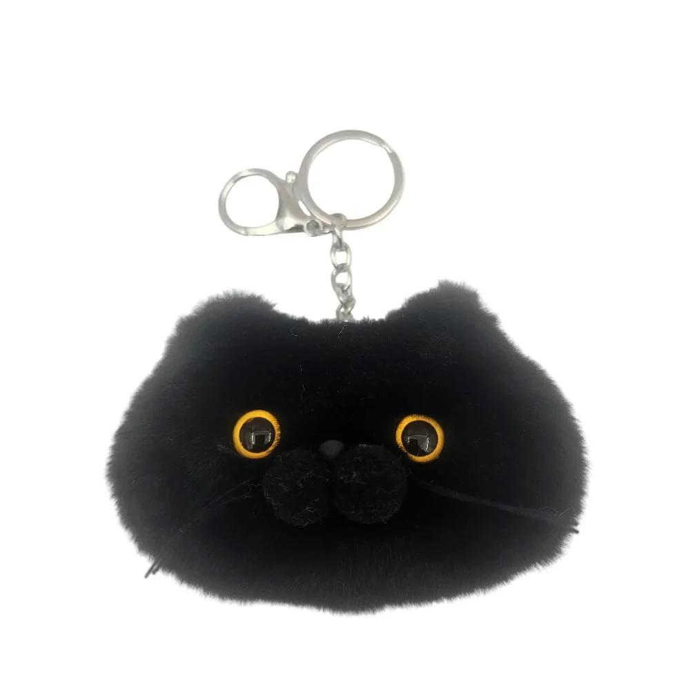 A black plush cat face keychain with yellow-rimmed eyes, a black nose, and a silver metal key ring clasp, shown on a plain white background.