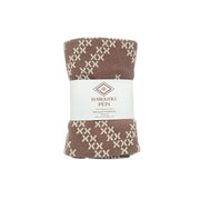 A folded knit blanket with a brown and cream geometric pattern, wrapped in a white paper band labeled 'HAWAUKI PEPI'.