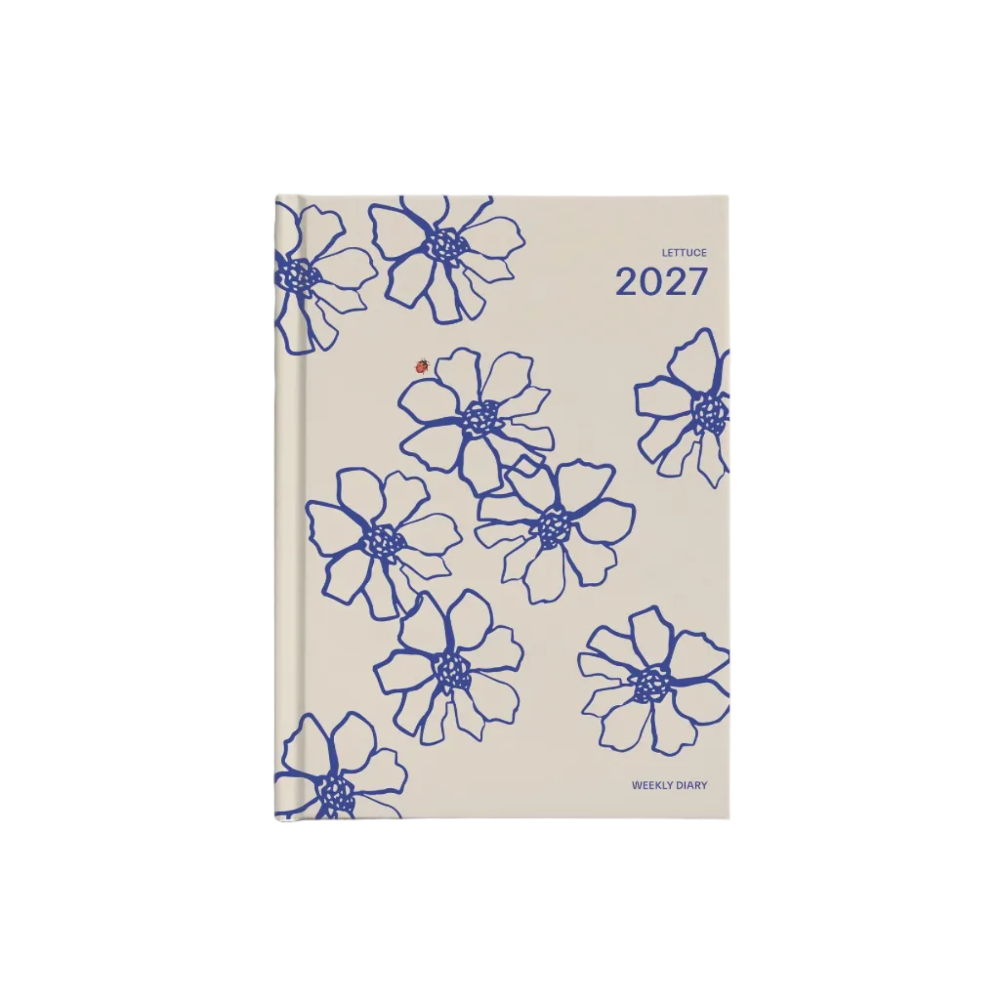 A 2027 daily planner with a beige cover decorated with blue floral line drawings, shown on a light gray background.