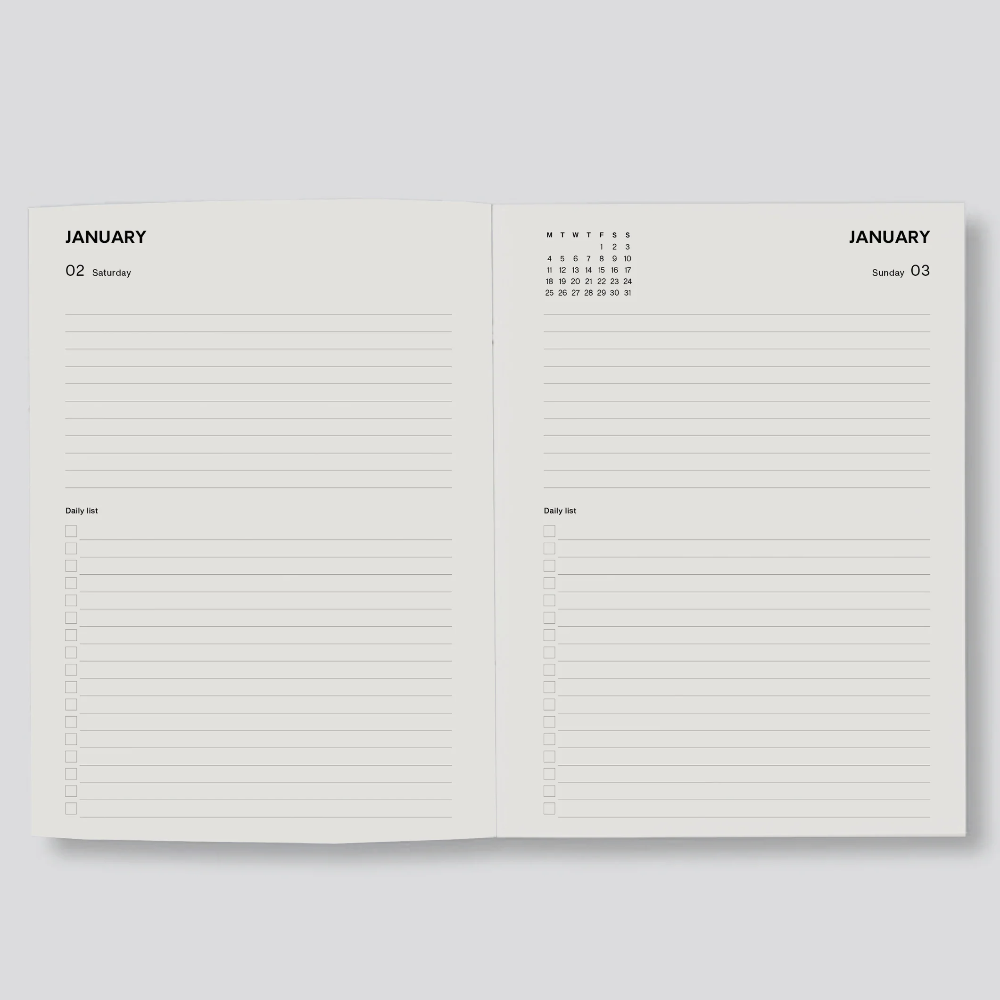 An open planner or notebook showing two blank interior pages for January, with lined writing areas and small calendar views at the top, photographed on a light gray background.