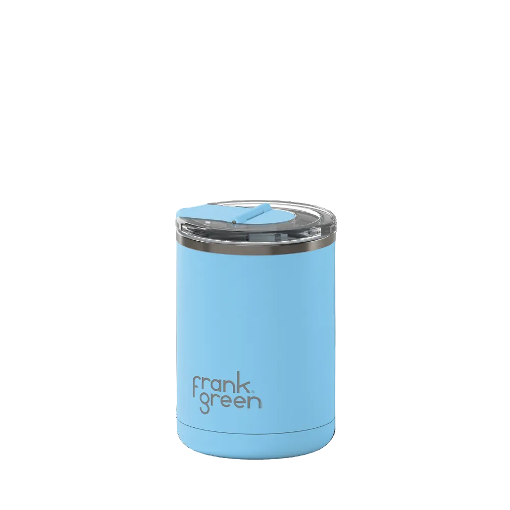 A light blue Frank Green vacuum-insulated tumbler with a clear lid and blue flip straw, shown on a plain white background.