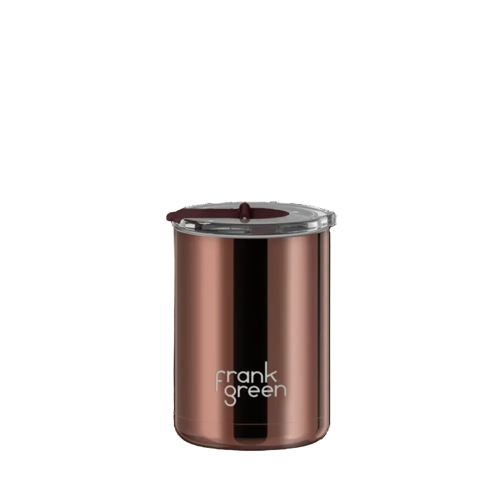 A Frank Green insulated tumbler in a metallic copper/rose-gold finish with a clear lid and dark brown silicone seal, shown on a plain white background.