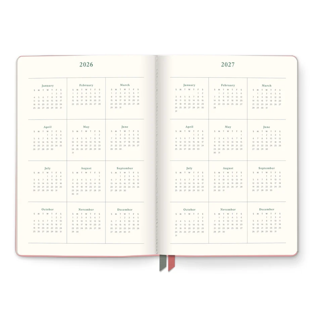An open planner or calendar showing the years 2026 and 2027 with monthly grids in muted green on warm off-white pages, with two ribbon bookmarks visible at the bottom.