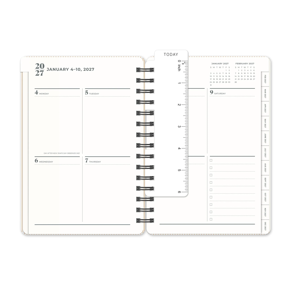 An open spiral-bound planner shown from the front, with two interior spread pages visible. The pages are white with black printed lines, dates, and calendar details, and a small ruler-like page element is overlaid near the top center.