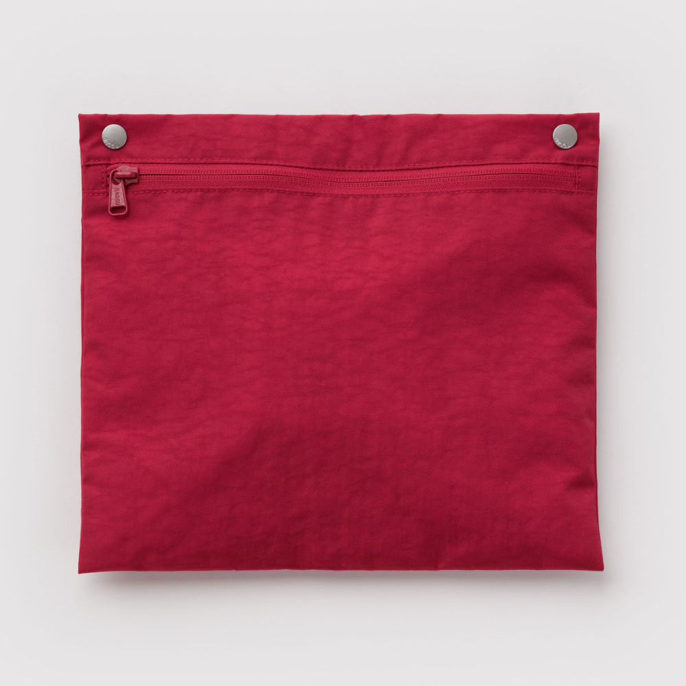 A folded red fabric pouch or sleeve with a horizontal zippered pocket and two silver metal snap buttons at the top, shown against a light gray background.