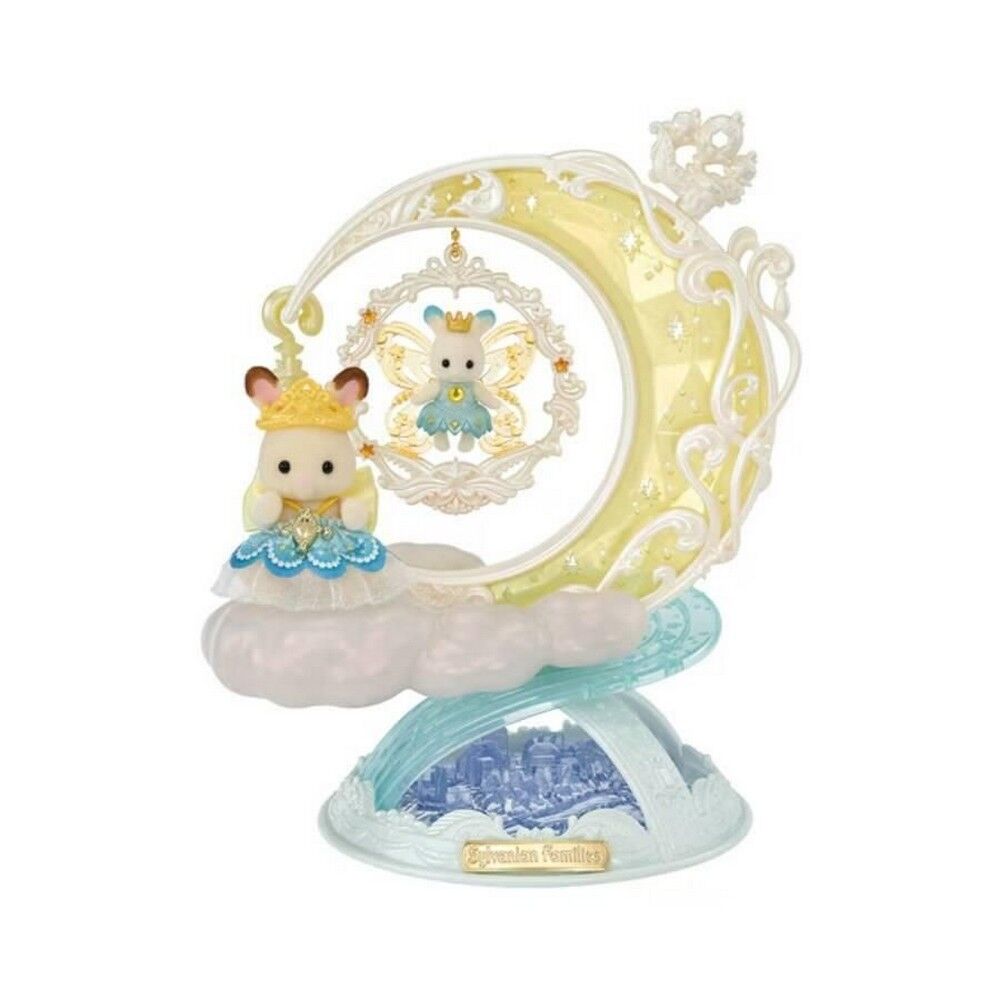 A decorative figurine of a small bear character in a blue dress with a gold crown, posed on a cloud-like base with a large pale yellow crescent moon and ornate white scrollwork behind it. A smaller matching figure appears reflected in the moon.