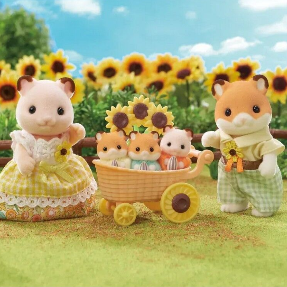 A family of cartoon animal characters in a sunflower field. A mother rabbit in a yellow gingham dress stands on the left, a father fox in a cream shirt and green check pants stands on the right, and three baby animal characters sit in a small yellow wagon in the center.