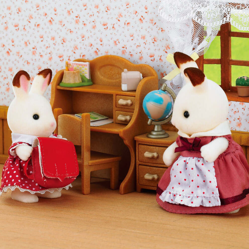 Two rabbit-like dolls in school uniforms standing in a room with a desk and globe.