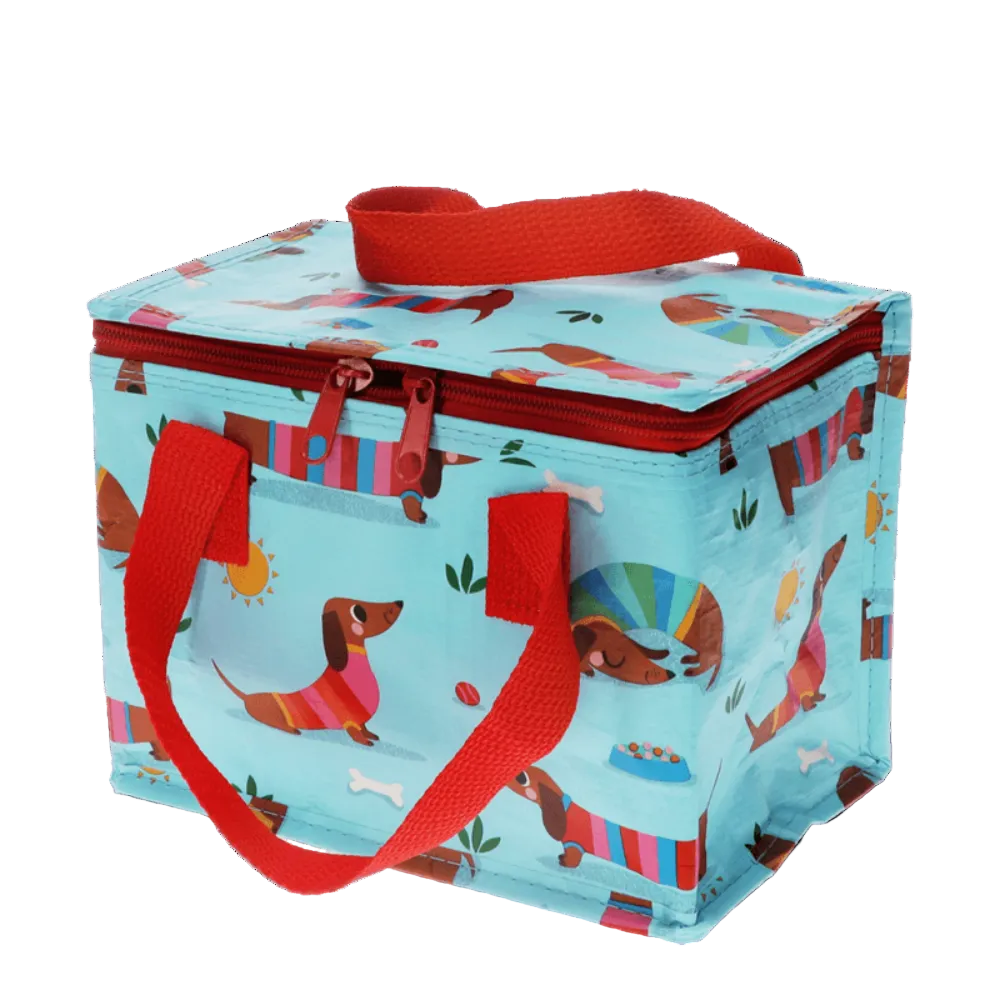 A light blue insulated lunch bag with a red handle and zipper, printed with cartoon dachshunds and colorful beach-style stripes, shown on a white background.