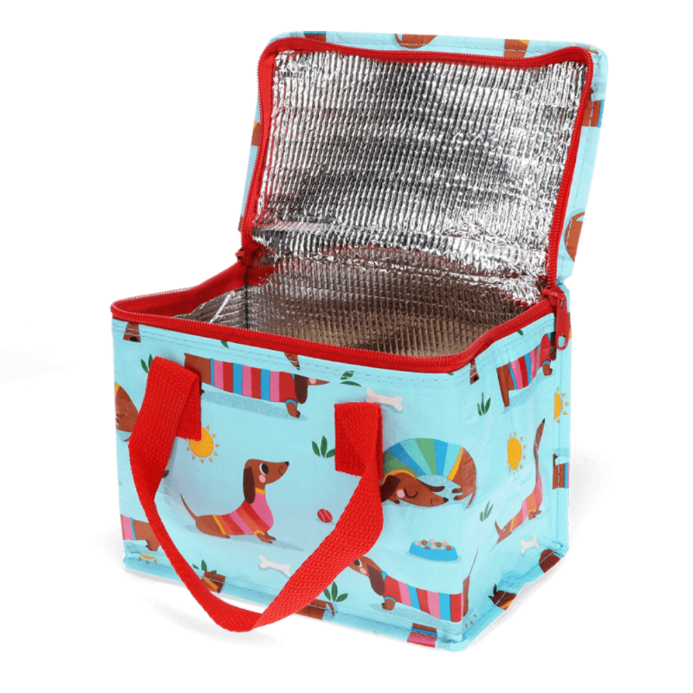 A light blue insulated lunch bag with a dachshund print, featuring red handles and a silver reflective lining, shown open on a white background.
