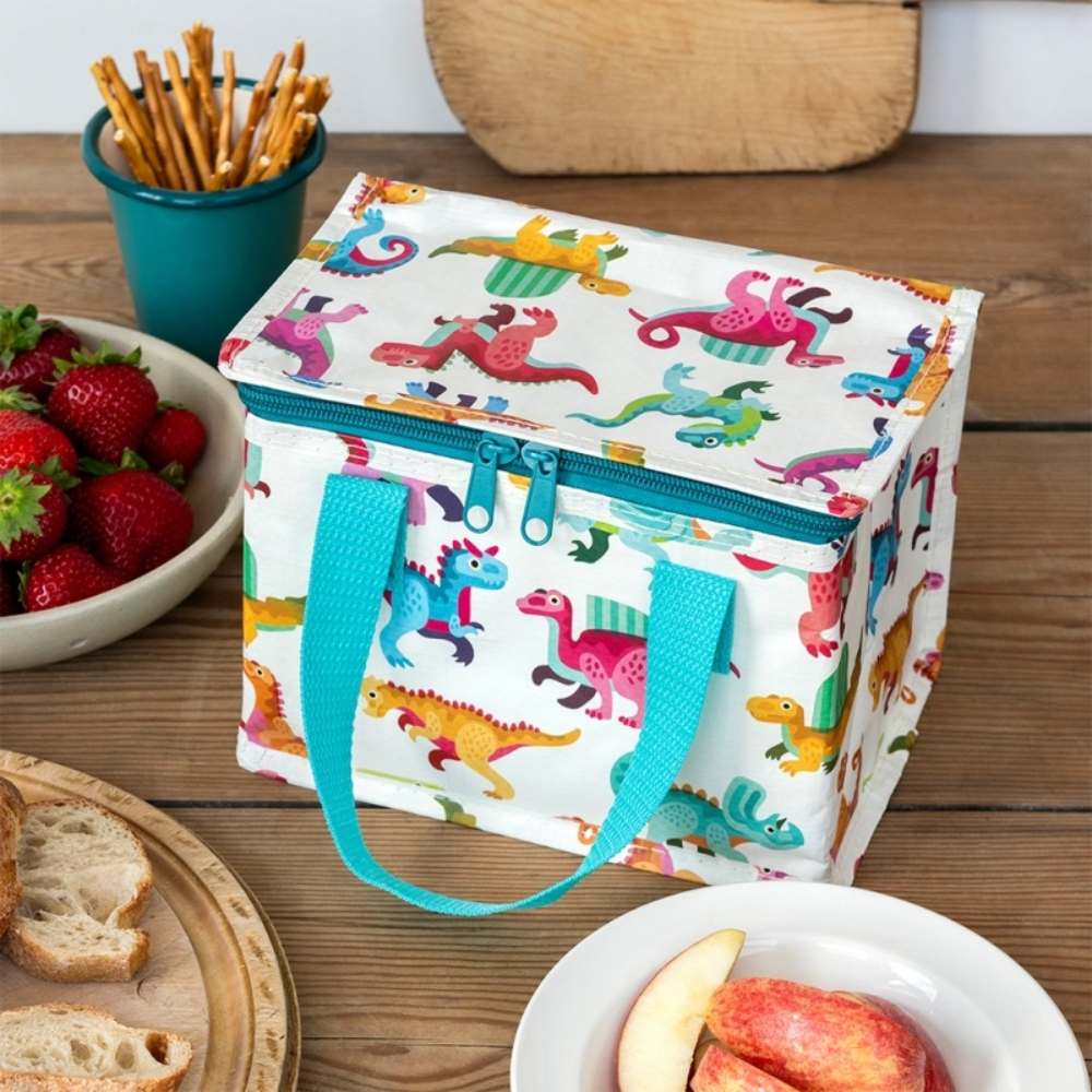  insulated lunch bag with dinosaur pattern on a wooden table with snacks