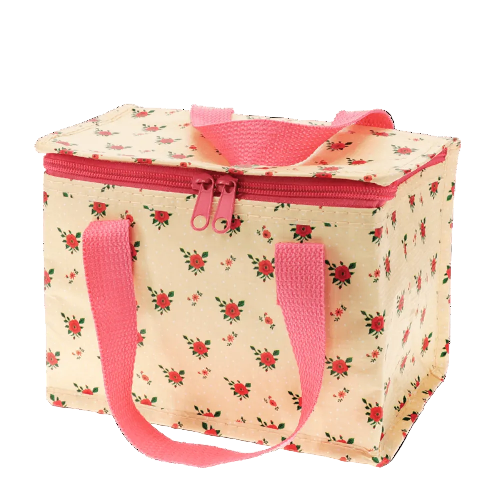 A square insulated lunch bag with a cream-colored fabric body, a red and green floral pattern, and bright pink handles and zipper trim, shown on a plain white background.