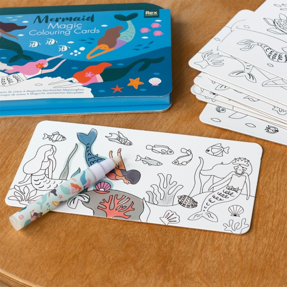 Mermaid-themed colouring cards with a pen on a wooden surface