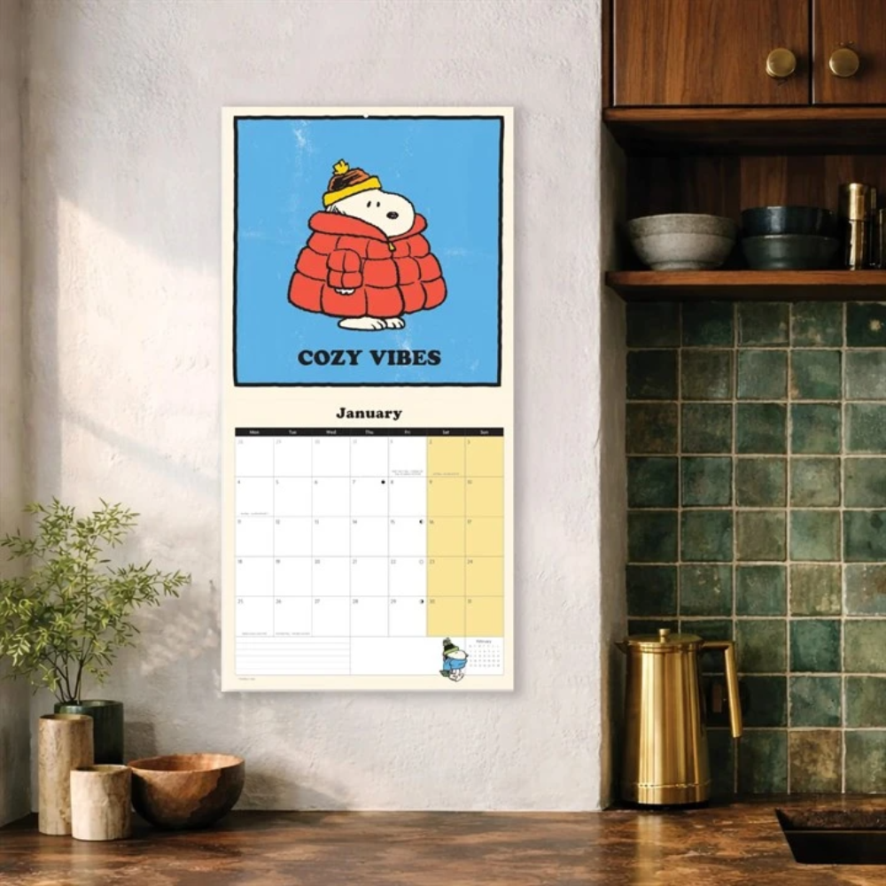 Calendar with cartoon character and 'Cozy Vibes' text in a kitchen setting