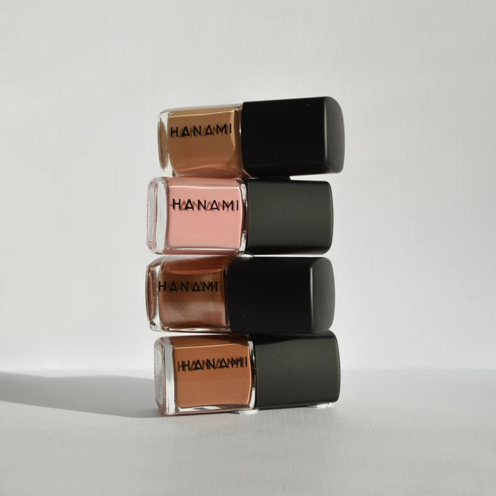 Four bottles of Hanami nail polish stacked on a light gray background