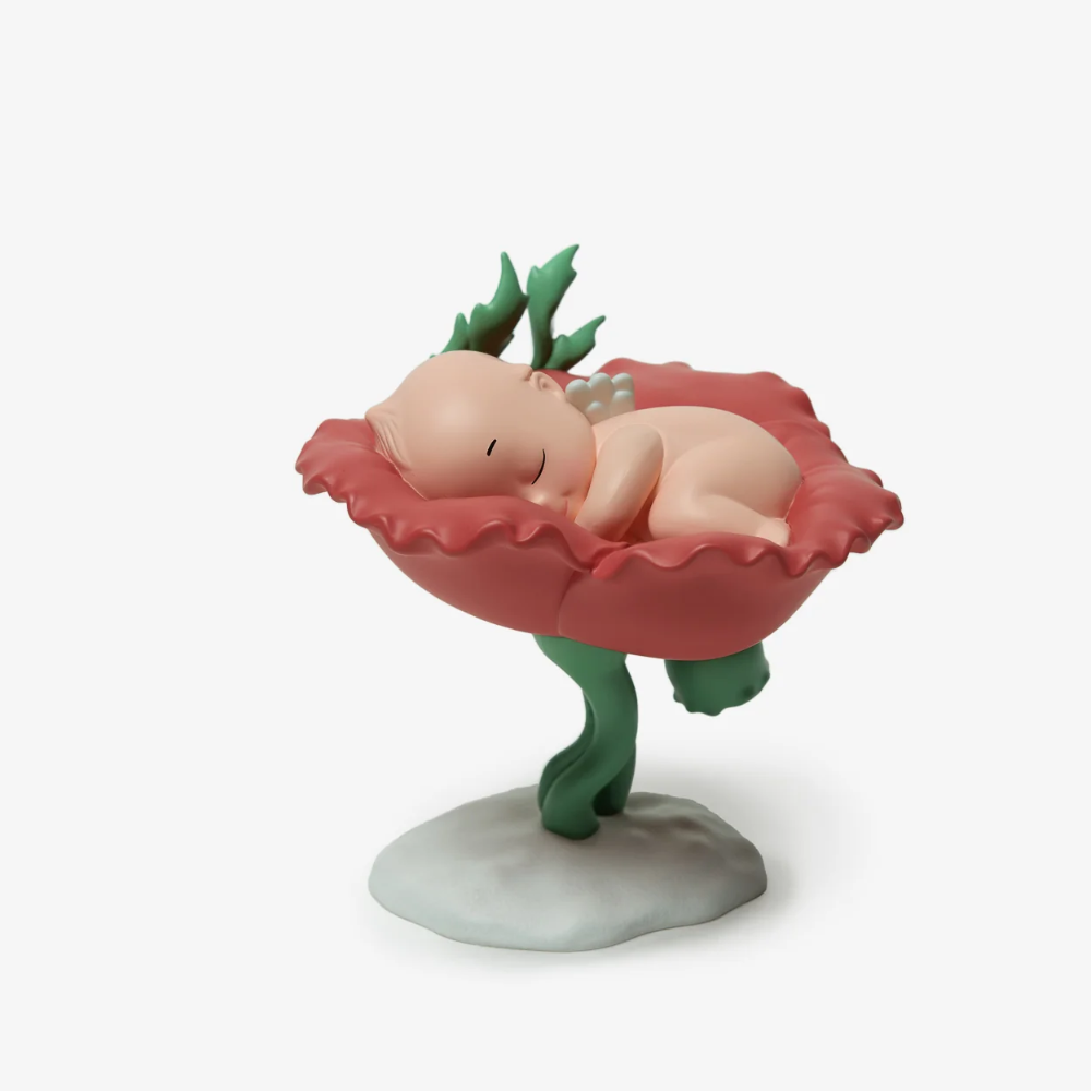Figurine of a baby in a flower bed on a white background