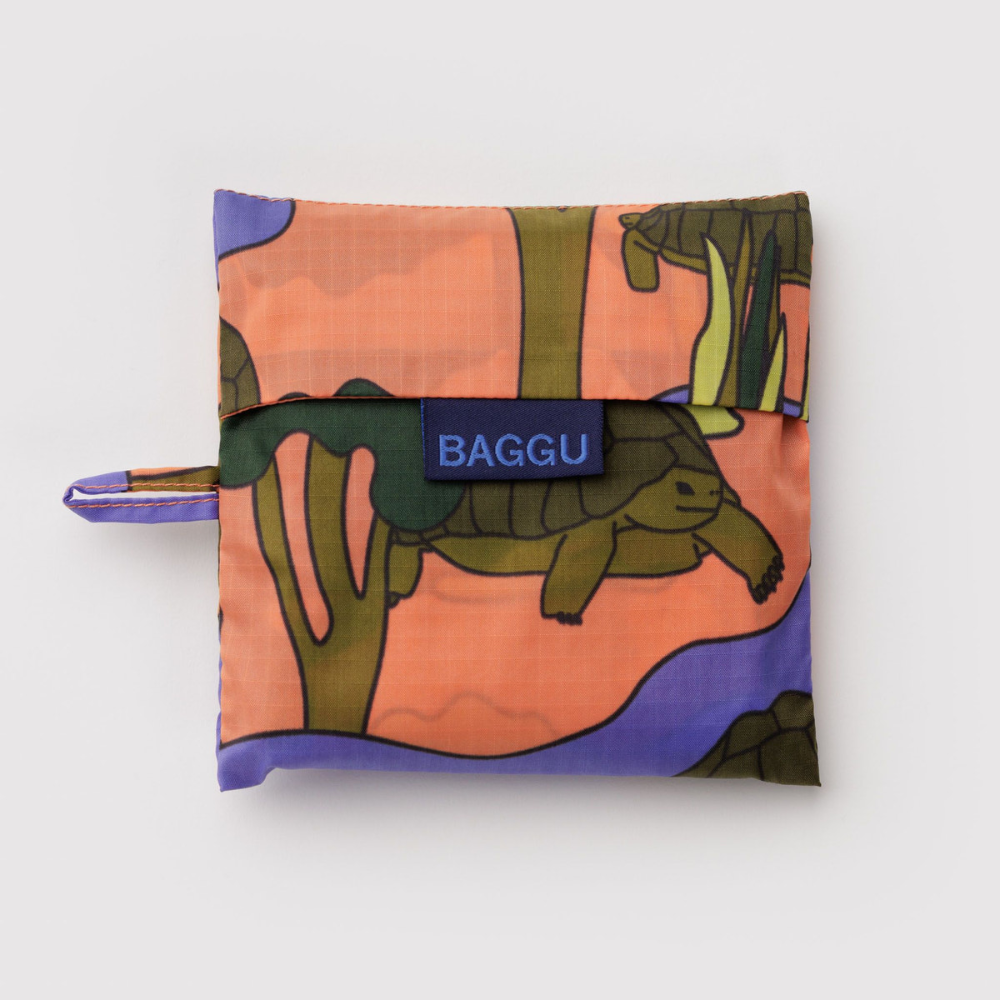 Folded reusable bag with turtle design and 'BAGGU' branding on a light gray background