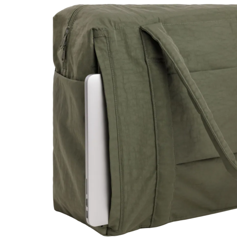 Green bag with a white laptop inside on a light gray background