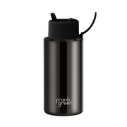 A dark metallic gray Frank Green water bottle with a black flip-top lid and carrying loop, set against a solid pale mint green background.