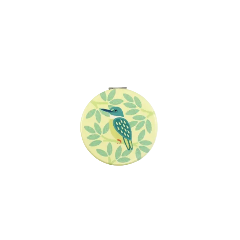 A display box of New Zealand cosmetic mirrors with three round mirrors shown above and inside the open box. The mirrors feature colorful tropical bird designs on pastel backgrounds, including a green kingfisher, a pink-and-blue toucan, and a purple kiwi.