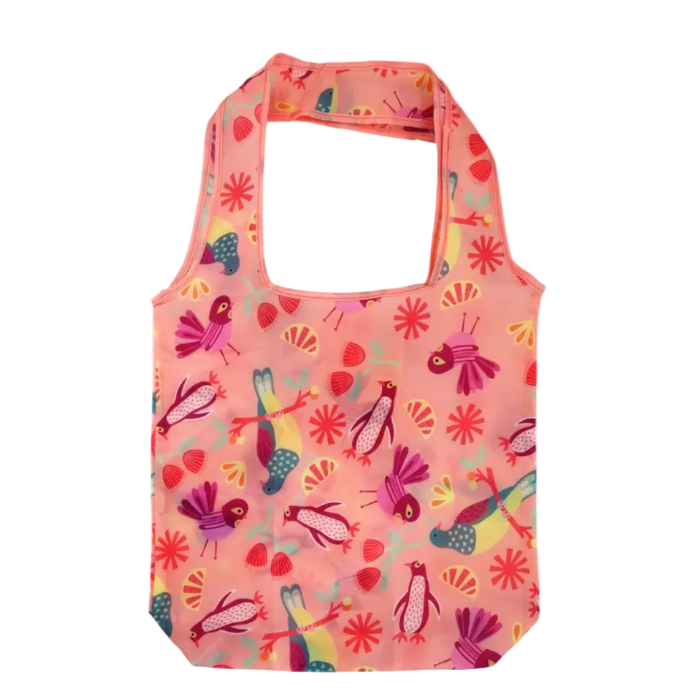 A reusable tote bag in coral pink with a colorful bird and flower print, shown next to its matching zippered pouch on a white background.