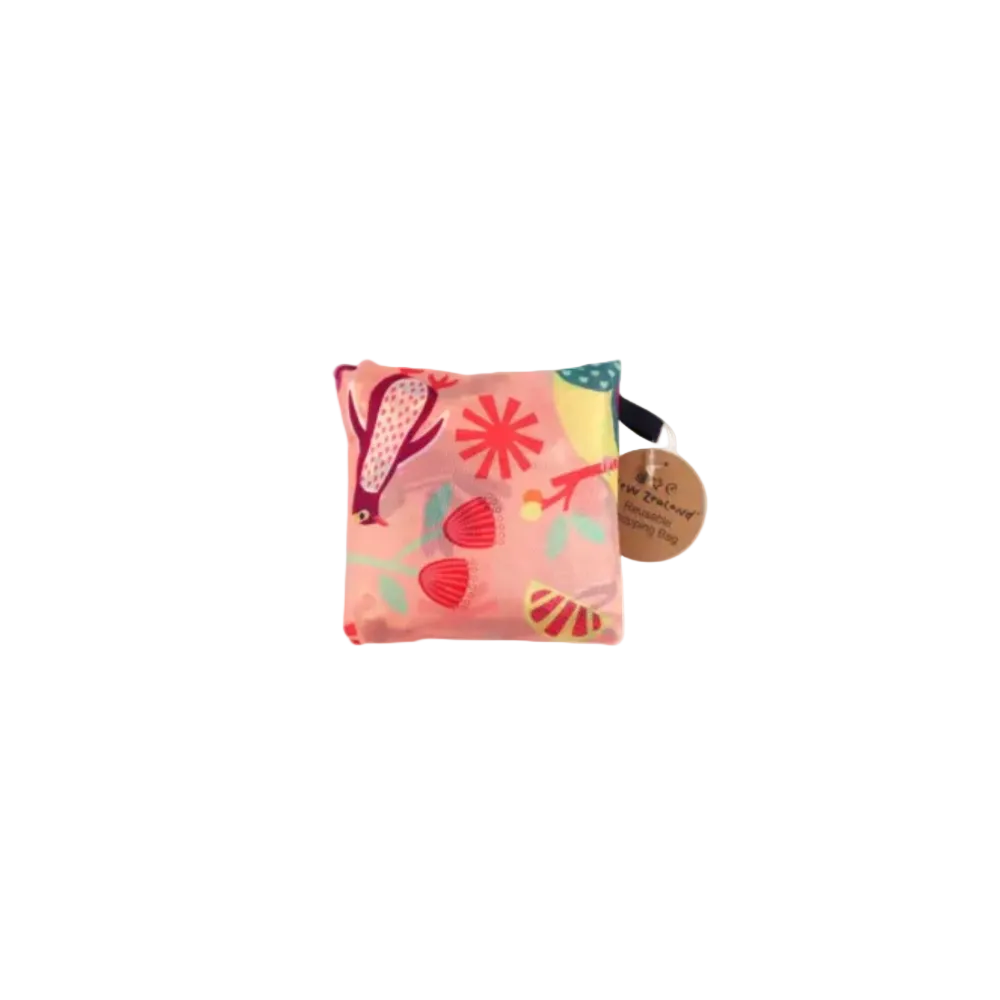 A reusable tote bag in coral pink with a colorful bird and flower print, shown next to its matching zippered pouch on a white background.