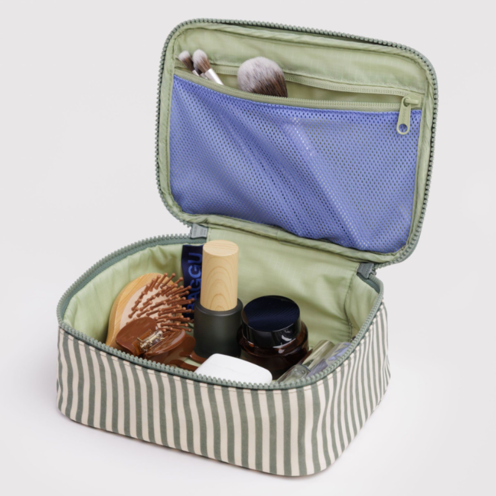 Open striped cosmetic bag with beauty products Baggu