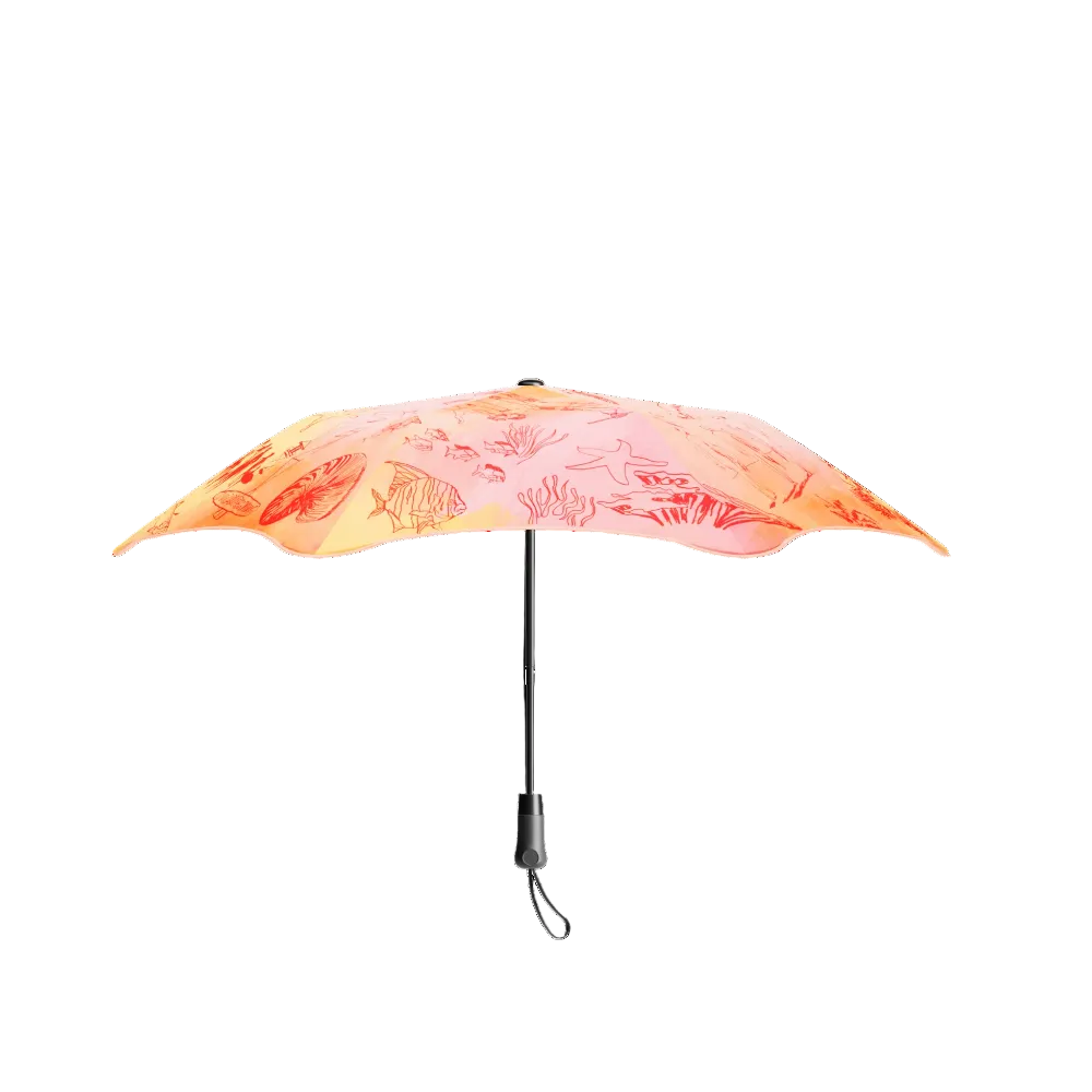 A compact folding umbrella with a vibrant orange and pink floral pattern, shown open against a solid white background.