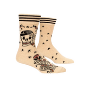 A pair of cream-colored crew socks with black stripes at the top, featuring a black skull smoking a pipe, scattered black stars, and a banner reading 'SORRY IN ADVANCE' with a rose near the foot.