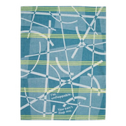 A rectangular fabric item, likely a tea towel or kitchen towel, featuring a blue and teal plaid pattern with white and light green intersecting lines and text that reads 'I'm unflapable. You can't flap me.