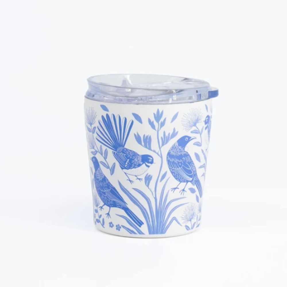A white ceramic tumbler with a clear plastic lid, decorated with a blue pattern of birds and botanical elements, set against a plain white background.