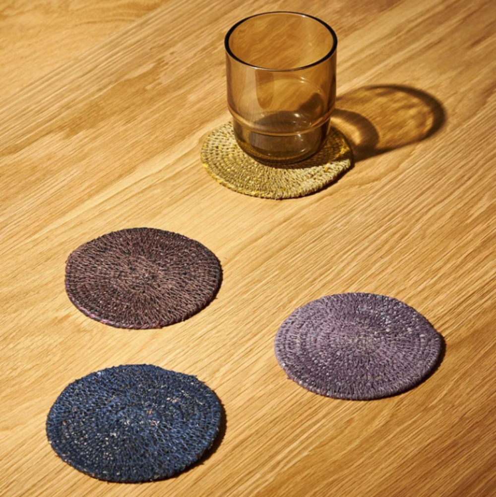 Set of round coasters on a wooden surface with a glass.