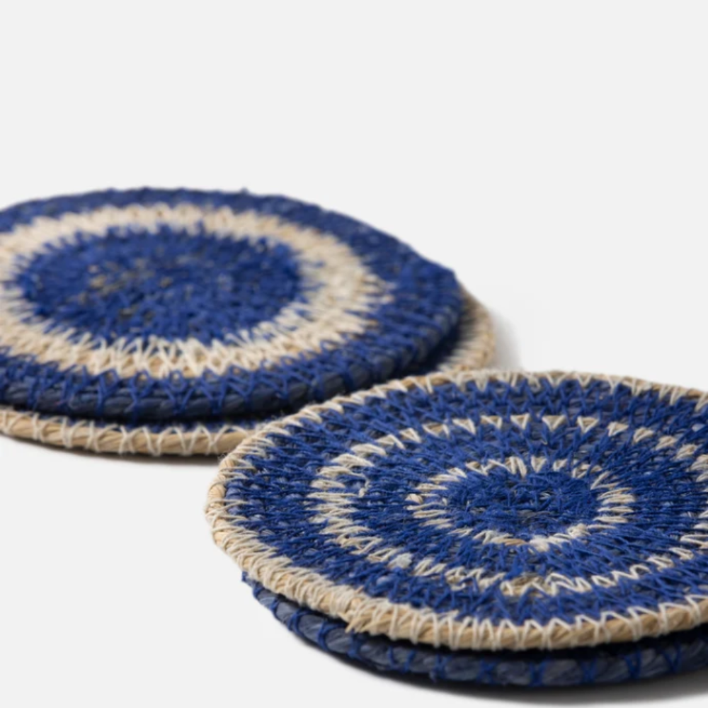 Two blue and beige circular coasters on a white background