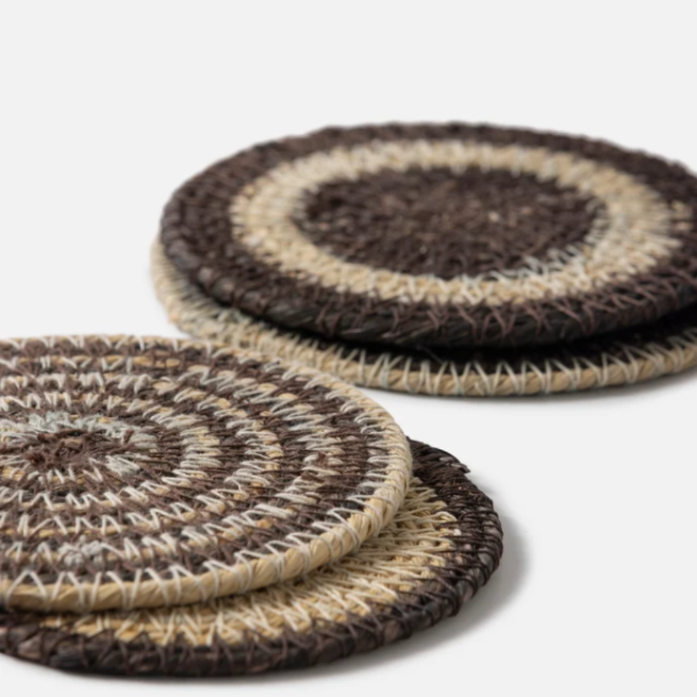 Set of woven coasters with brown and beige pattern on a white background