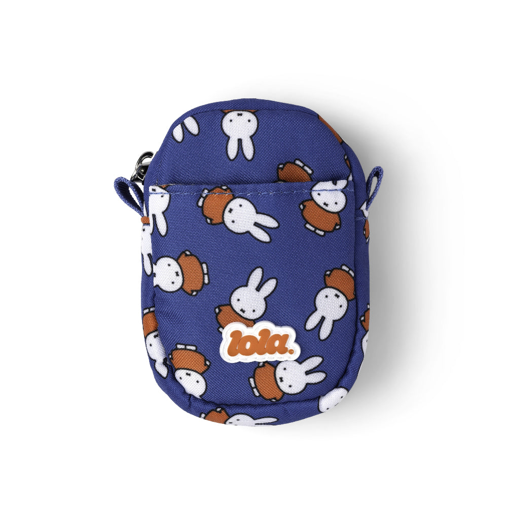 A small blue crossbody pouch featuring a repeating pattern of white rabbits and brown backpacks, with a white 'lola.' logo patch on the front, set against a plain white background.