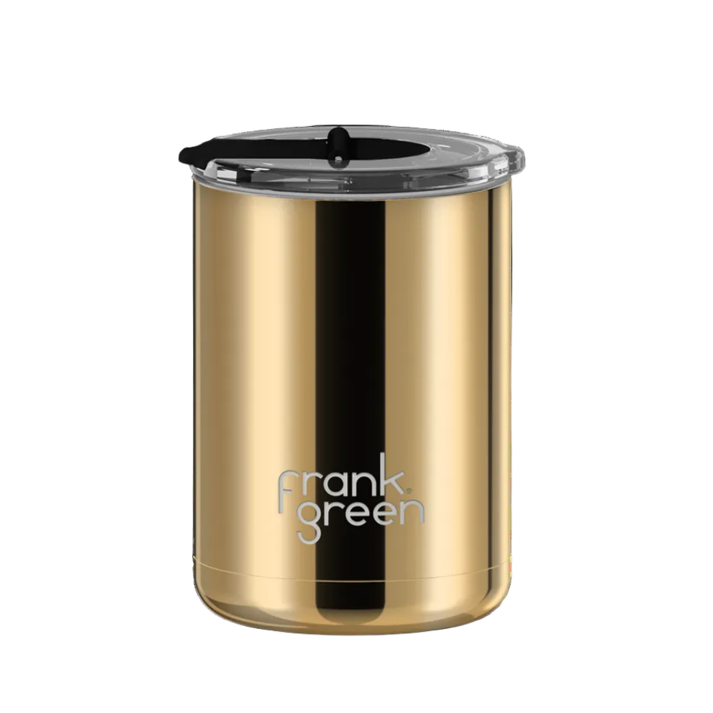 A gold stainless steel travel tumbler with a black lid and a vertical black stripe, featuring the 'frank green' logo near the bottom, set against a plain white background.
