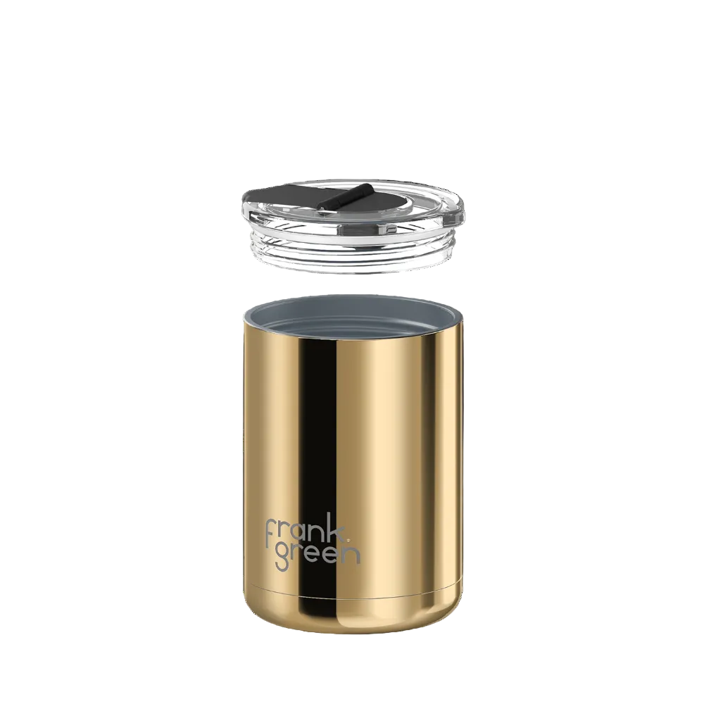 A gold stainless steel travel tumbler with a clear lid and dark gray interior, shown on a solid white background. The brand name 'frank green' is printed in silver on the lower front of the tumbler.