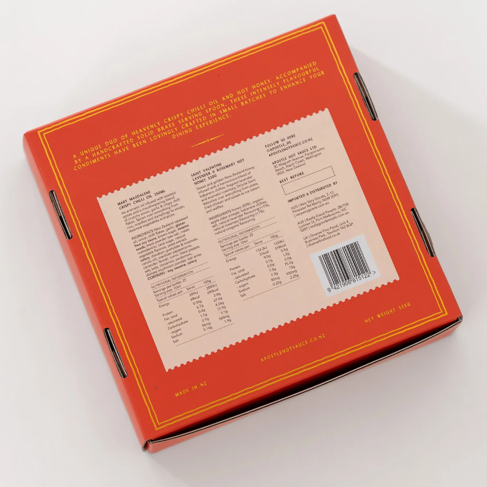 The back of a square orange cardboard box with yellow border lines and a large beige label containing text, shown on a clean white background.