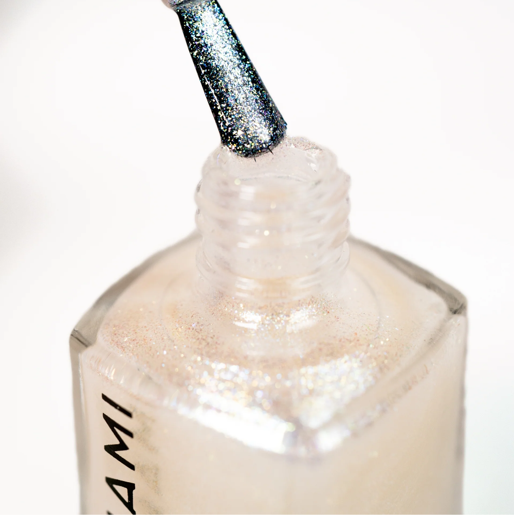 Close-up of a nail polish bottle with a brush applying polish.