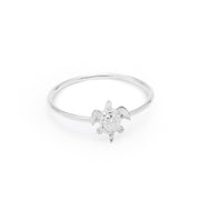 A silver ring featuring a small sea turtle design set with clear gemstones, photographed on a seamless white background.