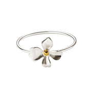 A sterling silver ring featuring a textured, organic-shaped flower with a gold plated center