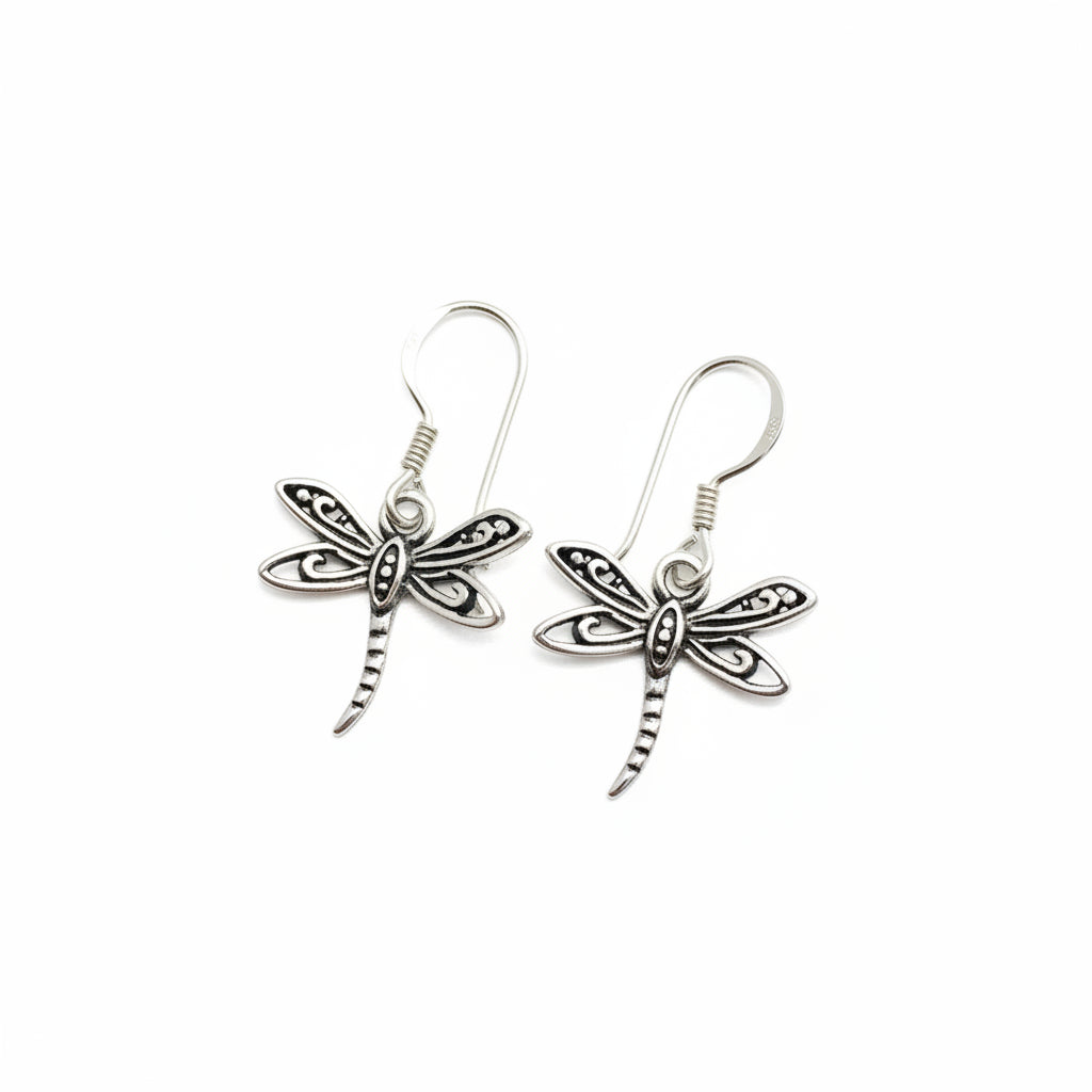 A pair of silver dragonfly drop earrings with detailed wing patterns and textured bodies