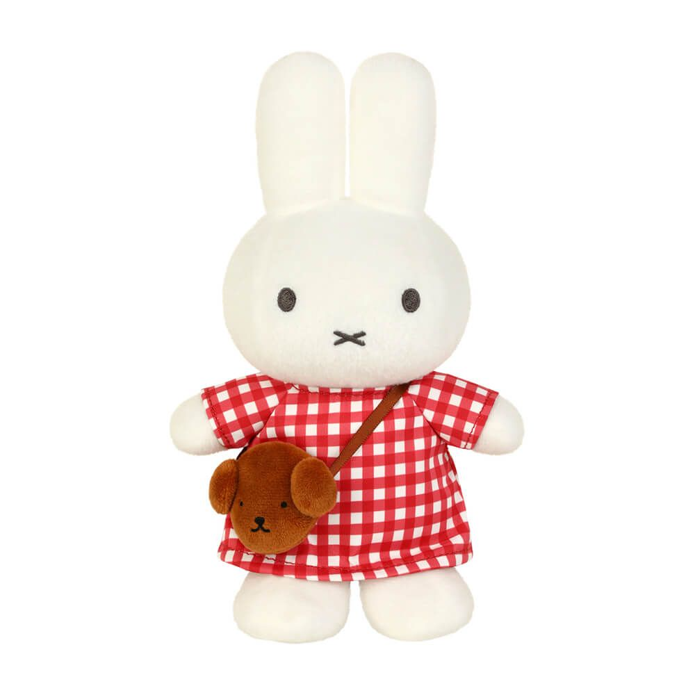 Plush toy rabbit in a red checkered outfit with a brown bag on a white background