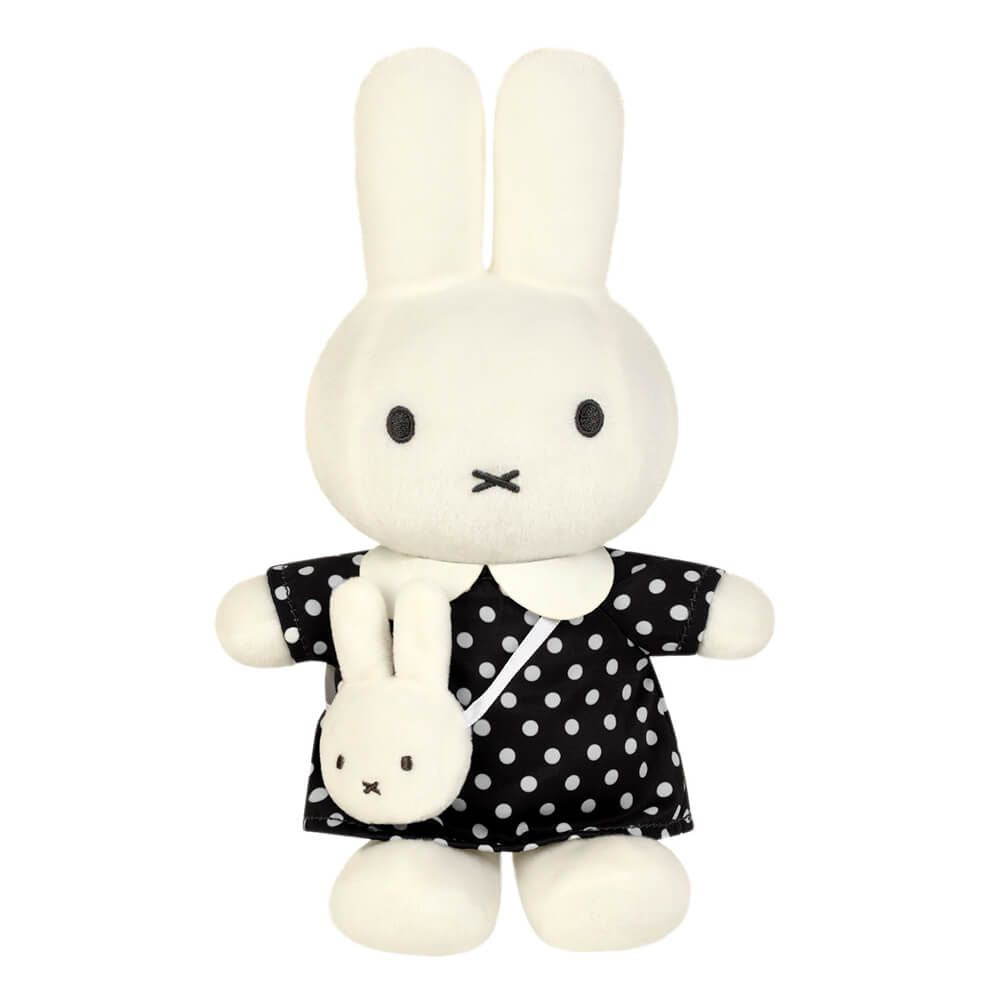 A plush rabbit toy with long white ears, black dot eyes, and a stitched black mouth, wearing a black dress with white polka dots and holding a small matching plush bunny bag.